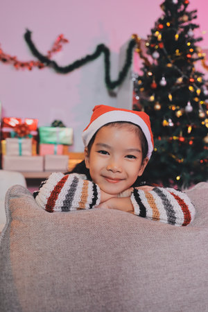 christmas, x-mas, winter, happiness concept - dreaming girl in santa helper hatの写真素材