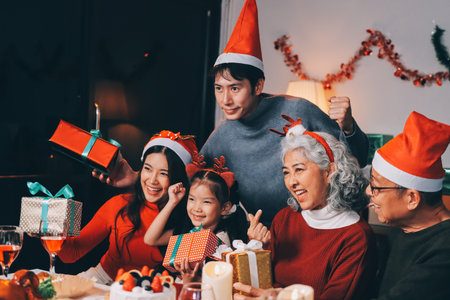 Happy family with gifts celebrating Christmas togetherの写真素材