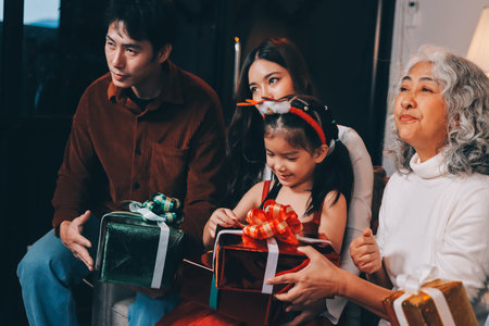 Portrait of Asian family exchanging presents during christmas at home. Attractive happy people...