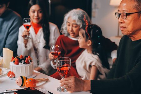 Multi-Generation Family Celebrate Christmas At Home Wearing Santa Hats And Antlers Opening Presentsの写真素材