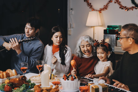 Multi-Generation Family Celebrate Christmas At Home Wearing Santa Hats And Antlers Opening Presentsの写真素材
