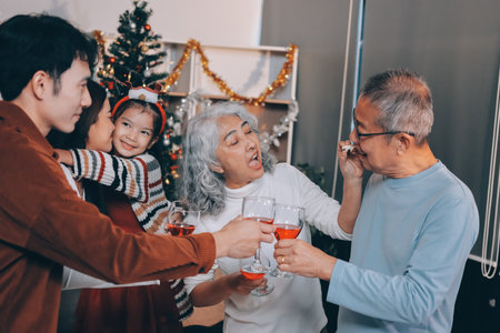 Merry Christmas! Happy family are having dinner at home. Celebration holiday and togetherness near tree.の写真素材