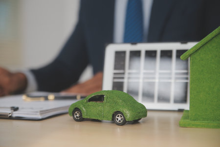 Judge gavel and miniature car symbolize auction or court case against driver who has accident and receiving vehicle insurance payment be on table in front of hands of lawyers. Selective focusの写真素材