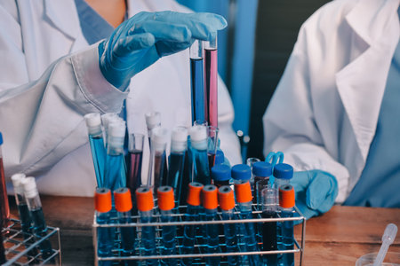 Blood test in the laboratory. Laboratory assistant working with the dispenser. Vacuum tubes with blood.の写真素材