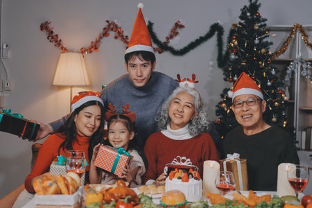 Happy family with gifts celebrating Christmas togetherの写真素材