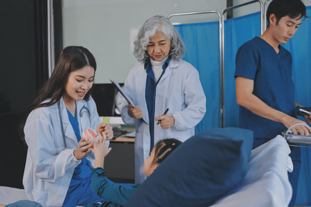 A team of doctors and nurses are working to treat a female patient in the patient's room.の写真素材
