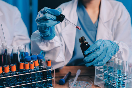 Blood test in the laboratory. Laboratory assistant working with the dispenser. Vacuum tubes with blood.の写真素材