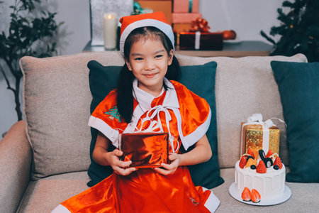 Little girl with Christmas gift at homeの写真素材