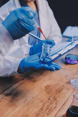 Blood test in the laboratory. Laboratory assistant working with the dispenser. Vacuum tubes with...