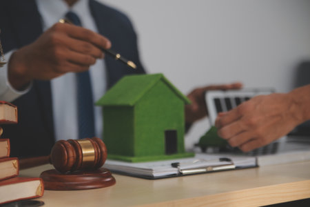 Auctioneer knocks down property sale by sample house and lawyer's gavel, judge mediates in property dispute in court car judge's gavel on wooden background Buying and selling real estate, housingの写真素材
