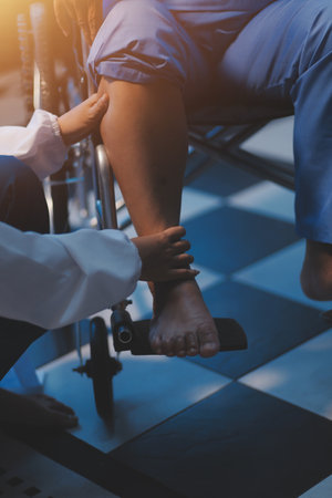 Asian young professional successful friendly female nurse in blue hospital uniform helping supporting physical therapy senior old pensioner unhealthy injury woman patient walking via four legs walker.の写真素材