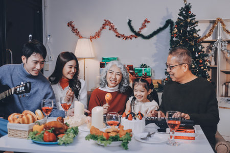 Multi-Generation Family Celebrate Christmas At Home Wearing Santa Hats And Antlers Opening Presentsの写真素材