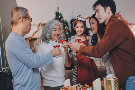 Merry Christmas! Happy family are having dinner at home. Celebration holiday and togetherness near tree.の写真素材