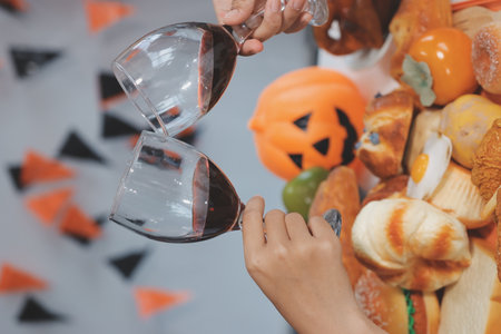 friendship, holiday and people concept - group of happy smiling friends in halloween costumes of vampire, devil, witch and cheetah at home partyの写真素材