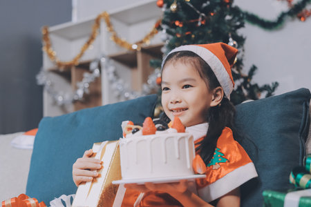Little girl with Christmas gift at homeの写真素材