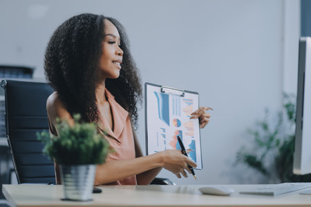 Female business person using digital tablet and laptop or remote working at home office, looking at digital tablet watching webinar, learning training, studying online seminar or video calling.の写真素材