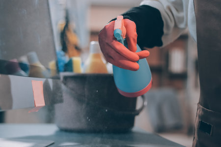 Woman cleaning computer desk in officeの写真素材