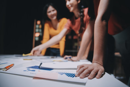 Business people working late at laptop in highrise officeの写真素材