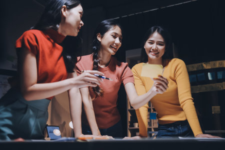Business people working late at laptop in highrise officeの写真素材