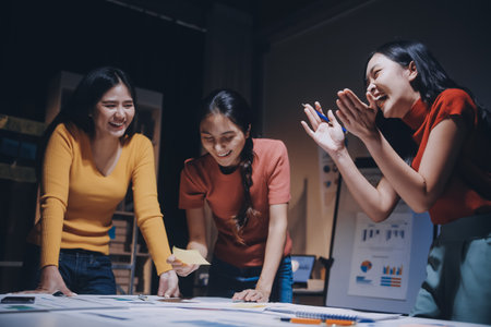 Business people working late at laptop in highrise officeの写真素材
