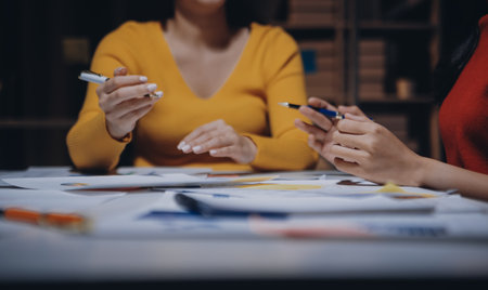 Business people working late at laptop in highrise officeの写真素材