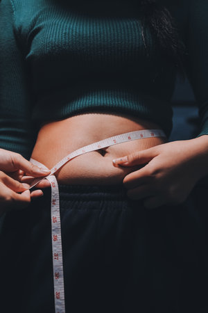 woman's hand holding belly fat