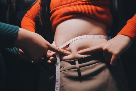 woman's hand holding belly fatの写真素材