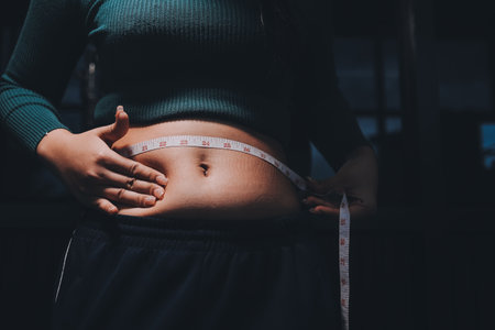 woman's hand holding belly fatの写真素材
