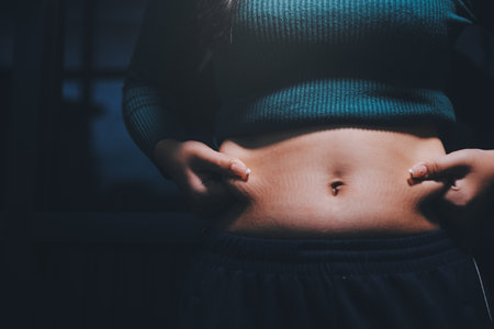 woman's hand holding belly fatの写真素材