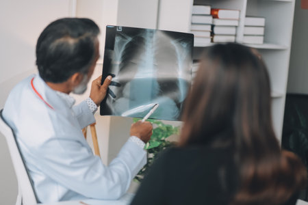 A Male doctor showing x ray film to female patient in hospital