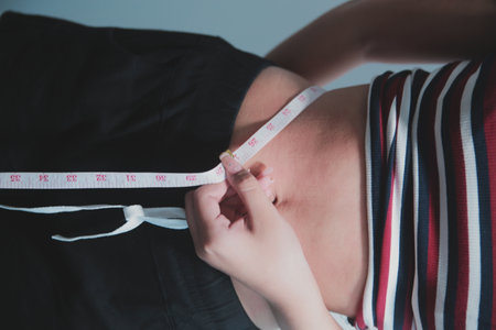 Woman measuring her waist with a tape measure. Concept of health and lifestyle.