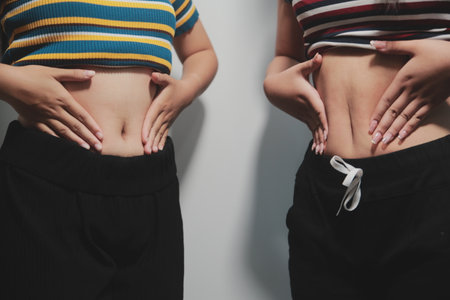 Women body belly. Woman hand holding belly. diet lifestyle concept to reduce belly and shape up stomach muscle.の写真素材