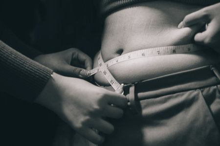 woman's hand holding belly fat