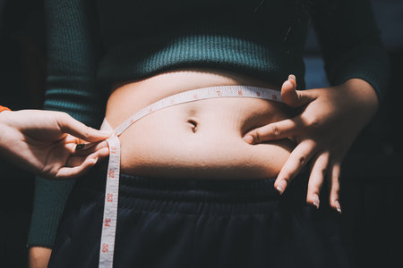 woman's hand holding belly fatの写真素材