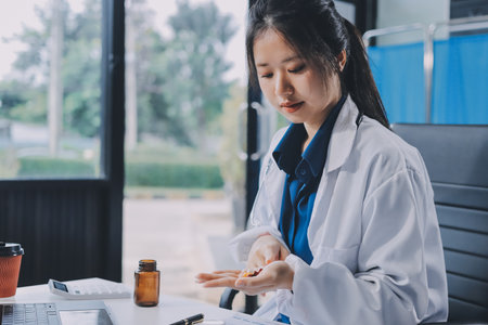 Positive doctor working on laptop in medical office.の写真素材