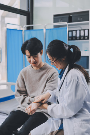 Female physician reads medical history while visiting her patientの写真素材