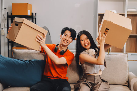 Smiling couple unpacking boxes in new house