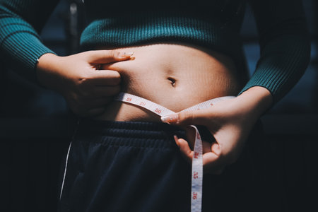 woman's hand holding belly fatの写真素材