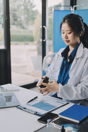 Positive doctor working on laptop in medical office.の写真素材