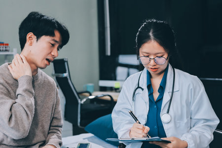Female physician reads medical history while visiting her patientの写真素材