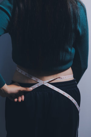 Woman Pinching Her Belly Fat With Left Handの写真素材