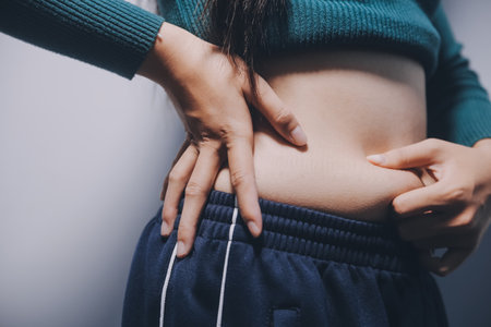 Woman Pinching Her Belly Fat With Left Handの写真素材