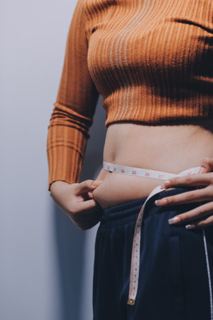 Woman Pinching Her Belly Fat With Left Handの写真素材