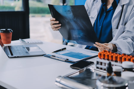 Positive doctor working on laptop in medical office.の写真素材