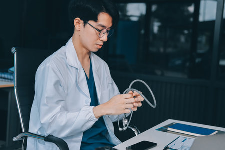 Positive doctor working on laptop in medical office.の写真素材