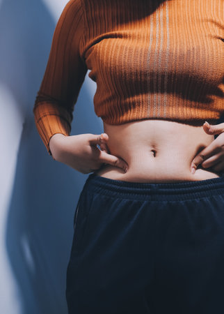 Asian Woman Pinching Her Belly With Left Hand