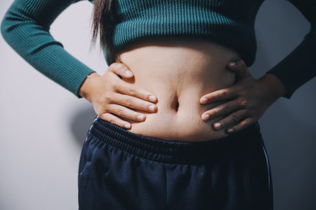 Woman Pinching Her Belly Fat With Left Handの写真素材