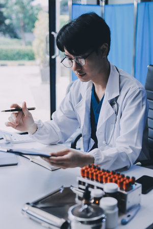 Positive doctor working on laptop in medical office.の写真素材