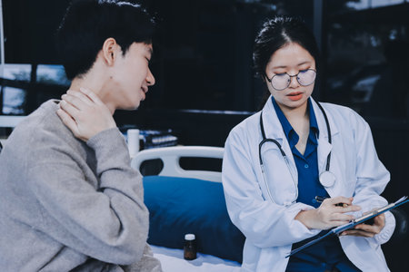Female physician reads medical history while visiting her patientの写真素材