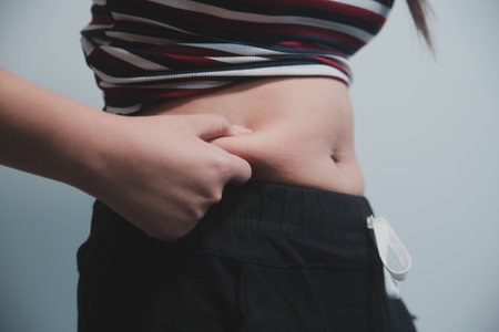 Women body belly. Woman hand holding belly. diet lifestyle concept to reduce belly and shape up stomach muscle.の写真素材